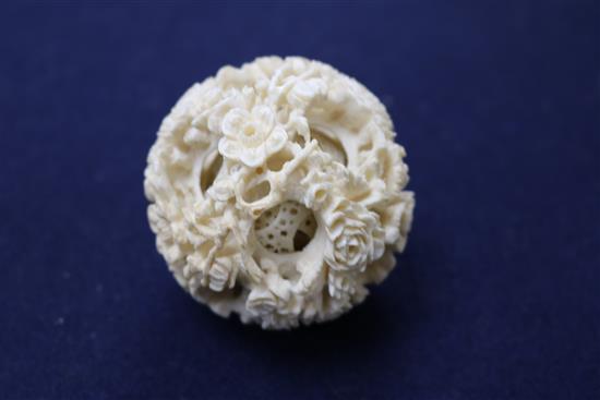 A Chinese ivory concentric puzzle ball and stand, early 20th century, ball 6.7cm, total height 23cm